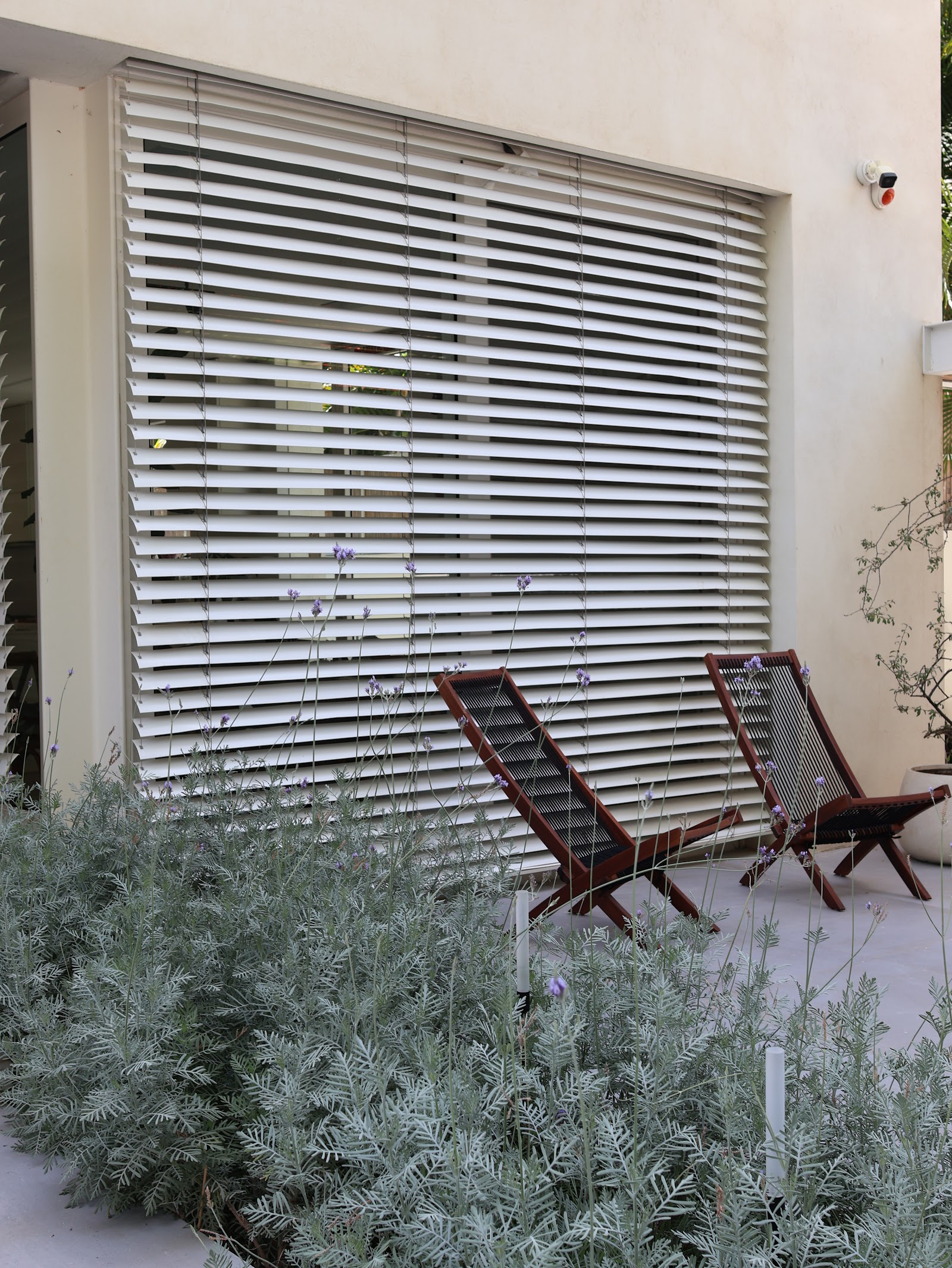 White Jungle, louvered shade with chairs and silver planting